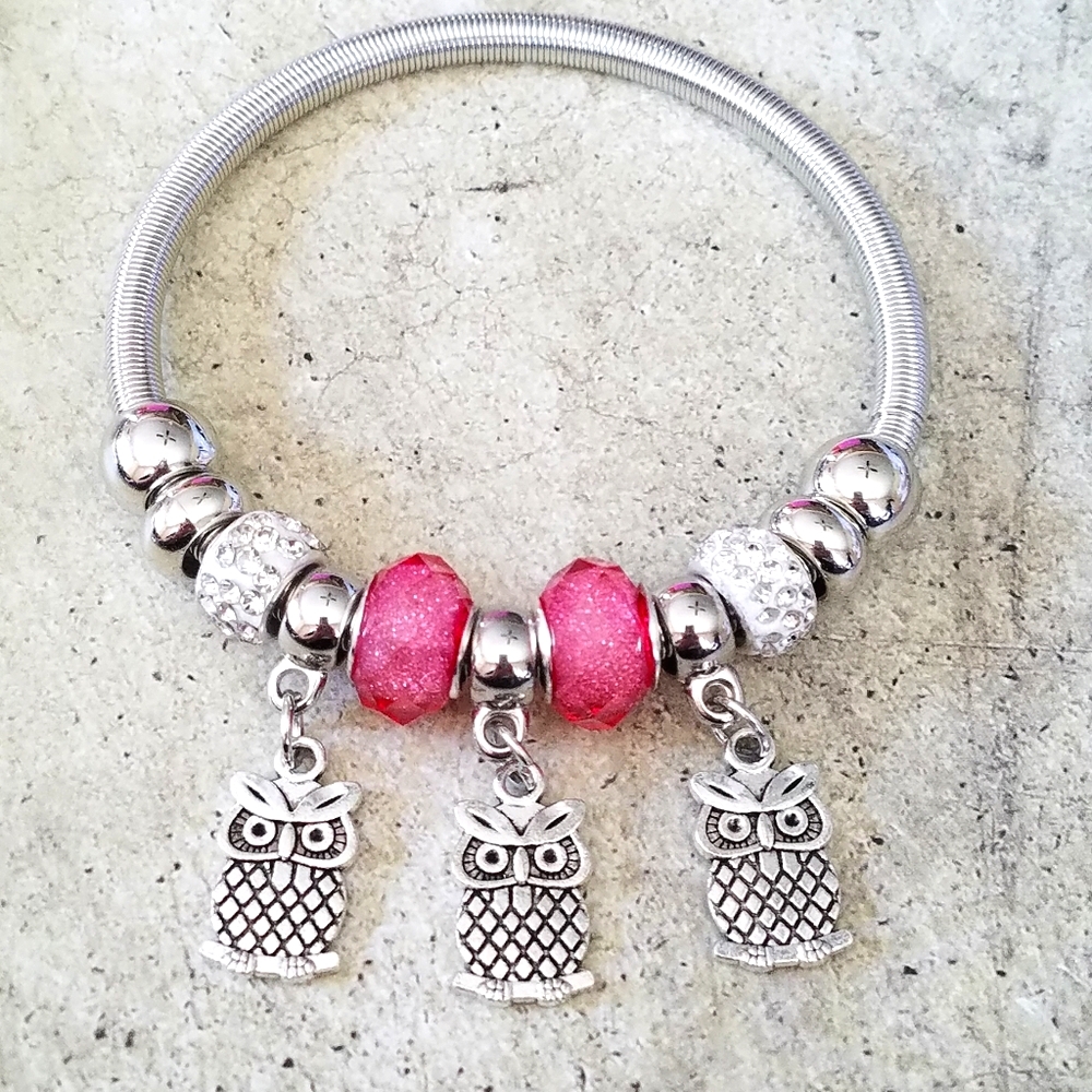 Pink and silver charm bracelet with three owls